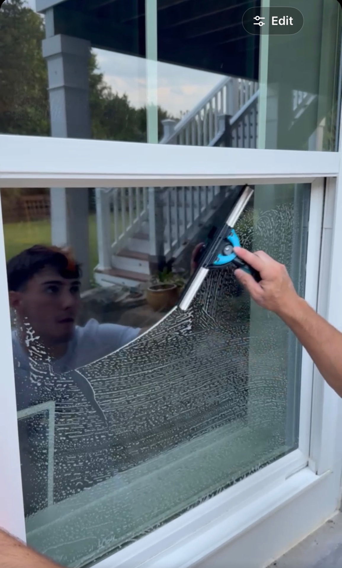 Professional window cleaning with a squeegee on a home window in Loudoun County Virginia