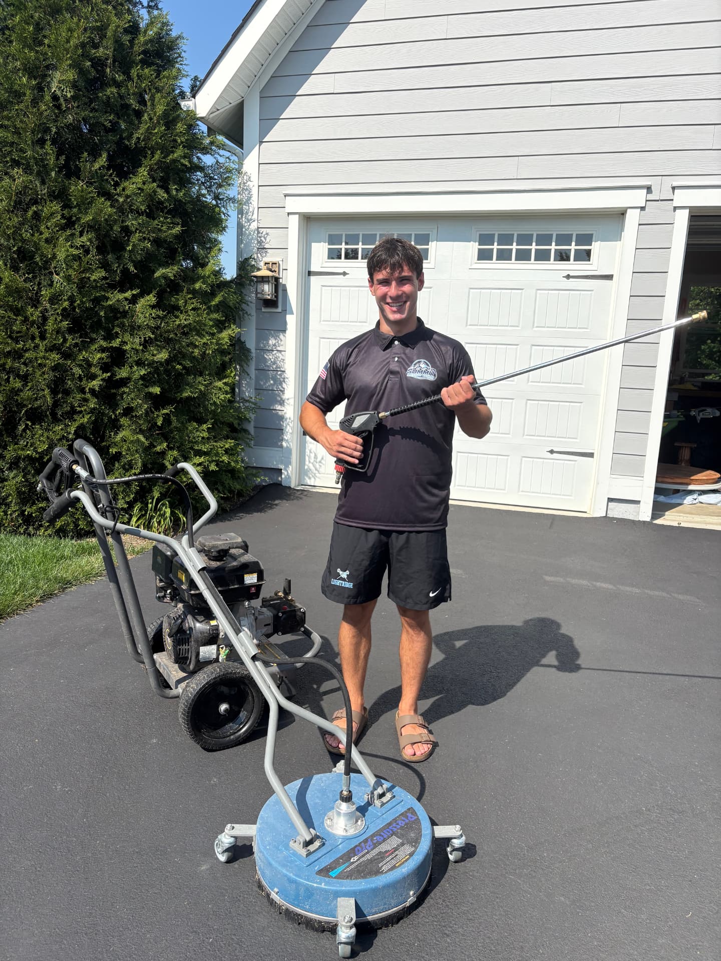 Owner of Summit Pressure Washing with professional equipment in front of a Loudoun County home